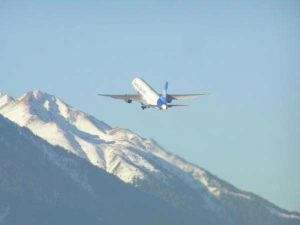 Ein Flugzeug startet vom Innsbrucker Flughafen in Richtung der schneebedeckten Berge